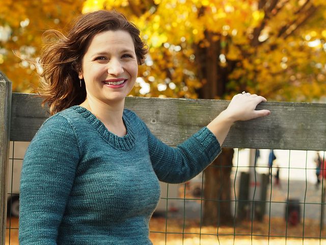 Christina in her 2014 Rhinebeck sweater, smiling against a backdrop of fall leaves.