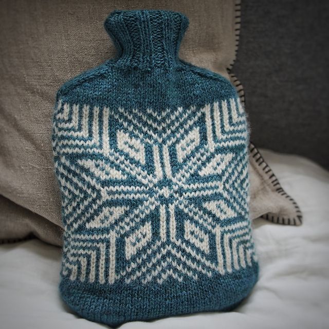 stranded knitting water bottle cover with a star motif in soft blue and cream yarn