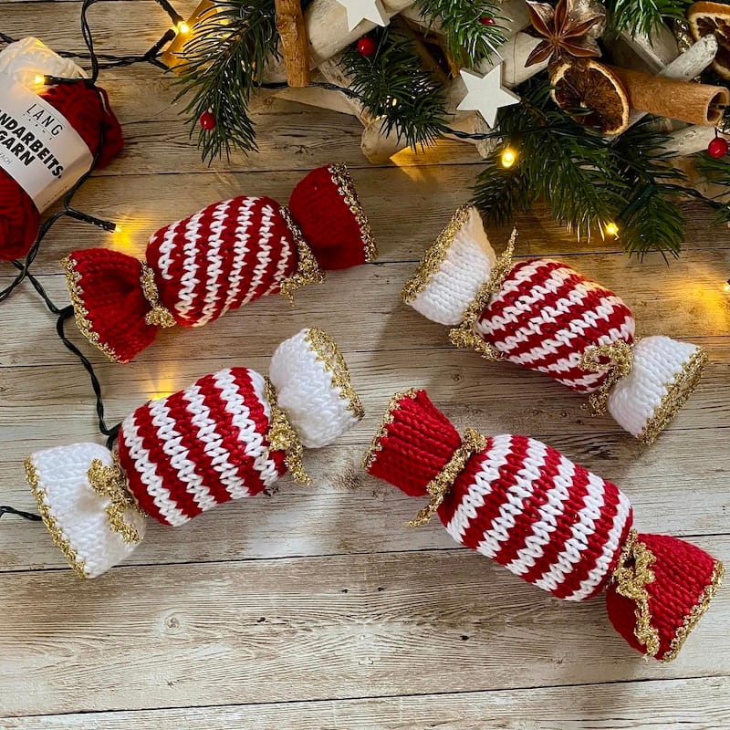 Small whimsical handknit candies in red and white stripes, with gold accents.