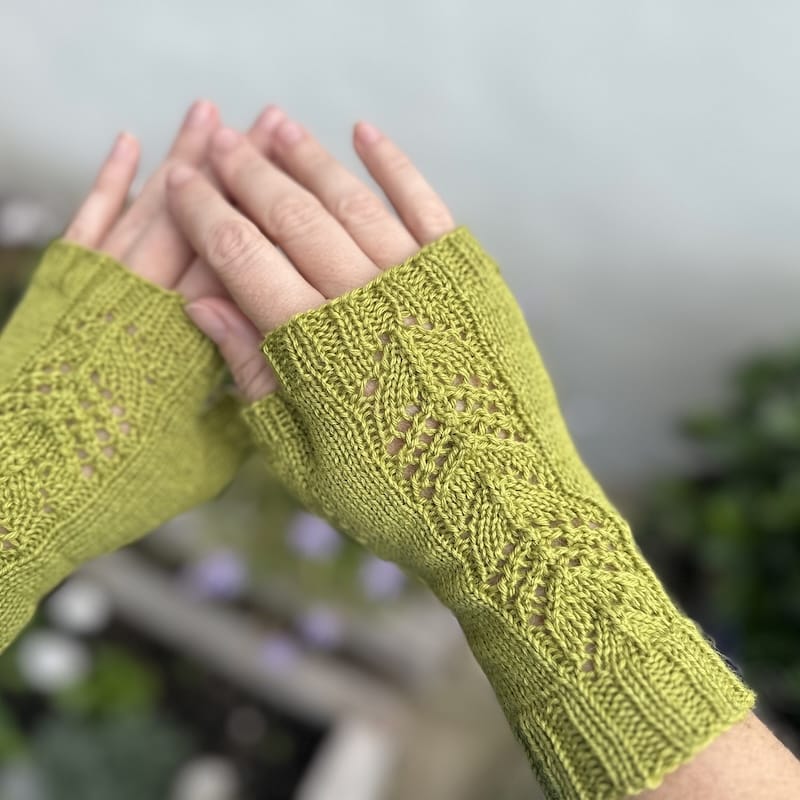 hands wearing spring green lace-detailed fingerless gloves